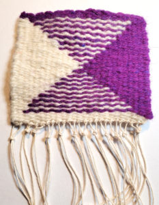 Small tapestry weaving in purple and white